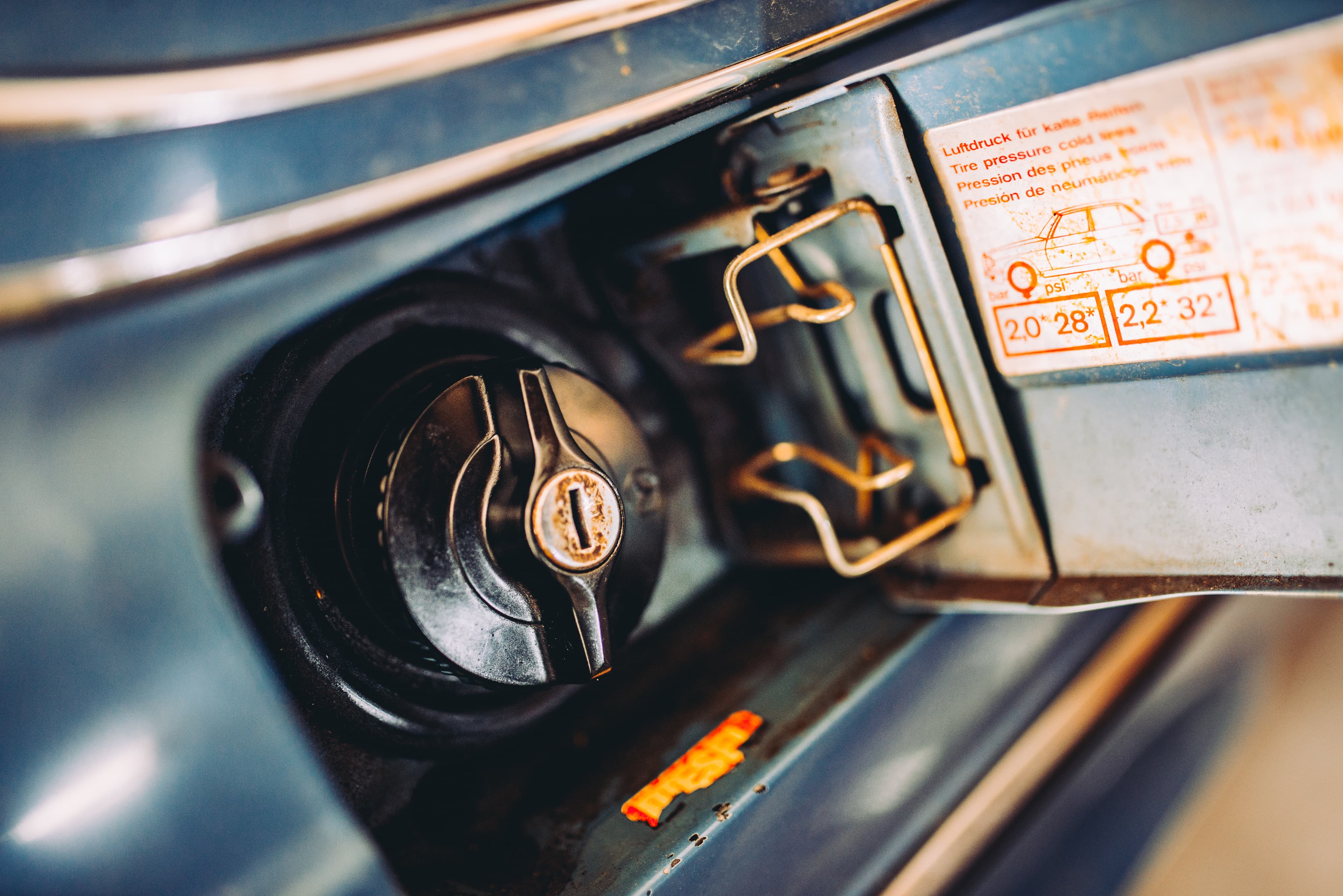 Closeup of a black plastic fuel tank cap on a classic car