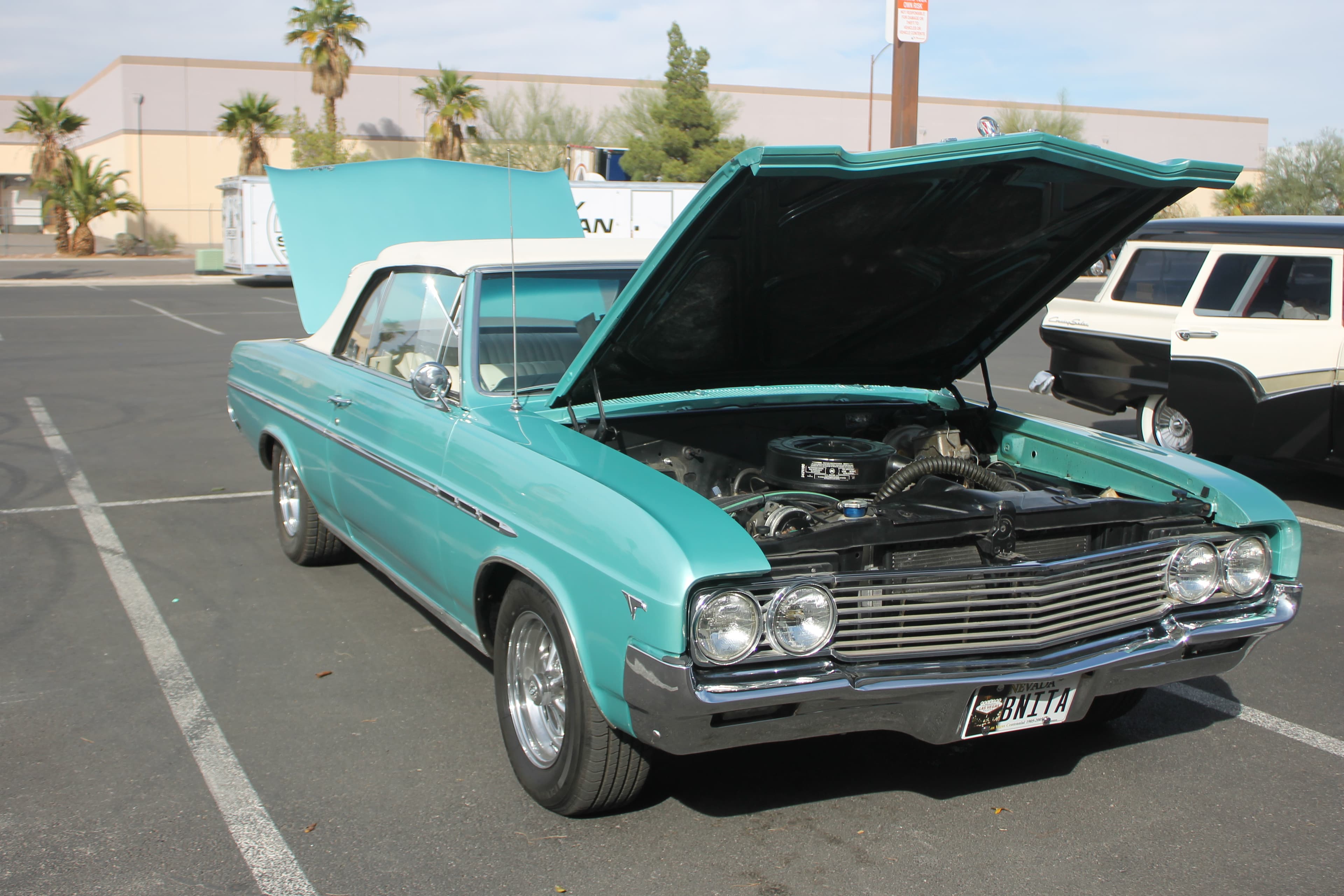 Buick Skylark with hood open displaying engine at a classic car show